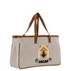 A beige canvas tote bag with a brown handle and a printed image of a chow dog's face, along with the name "OSCAR" below it.