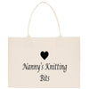A beige tote bag with the text "Nanny's Knitting Bits" printed on it, along with a small black heart symbol.
