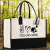 A black and white tote bag with a printed design on it, featuring the words 