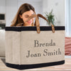 A woman is standing behind a large tote bag with the name "Benda" and "Joan Smith" printed on it.