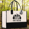 A black and white tote bag with a printed design on it, featuring the text 