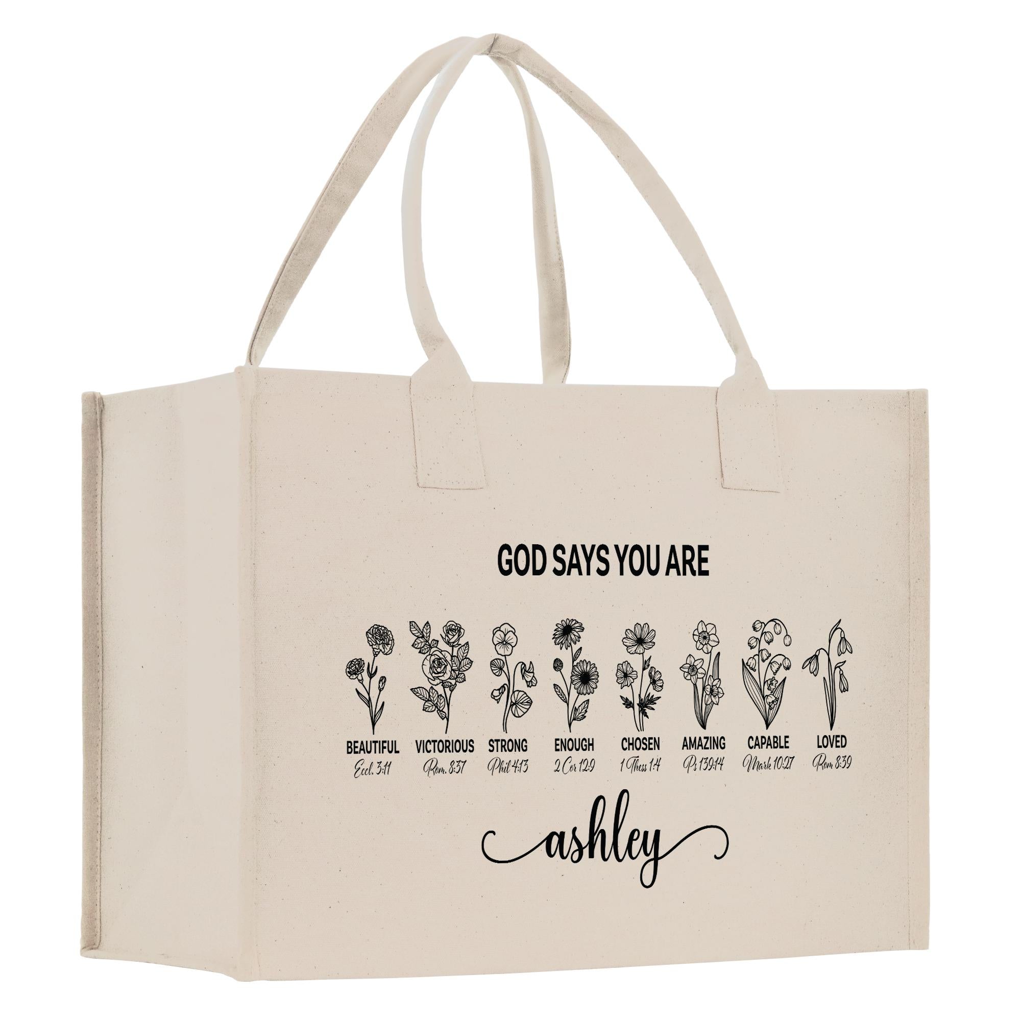 A beige canvas tote bag with a printed design featuring a series of flower illustrations and the text &quot;God says you are Ashley&quot; printed on it.