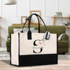 a black and white bag with a flower on it