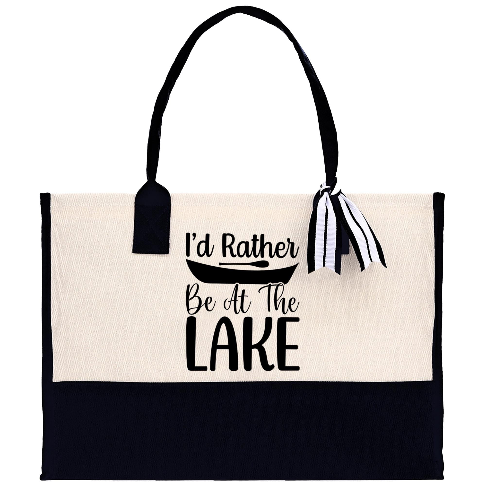 A tote bag with a black and white design, featuring the text "I'd Rather Be At The Lake" printed on it.