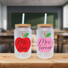 a couple of glass jars sitting on top of a wooden table