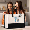 two girls sitting on a couch looking at a bag