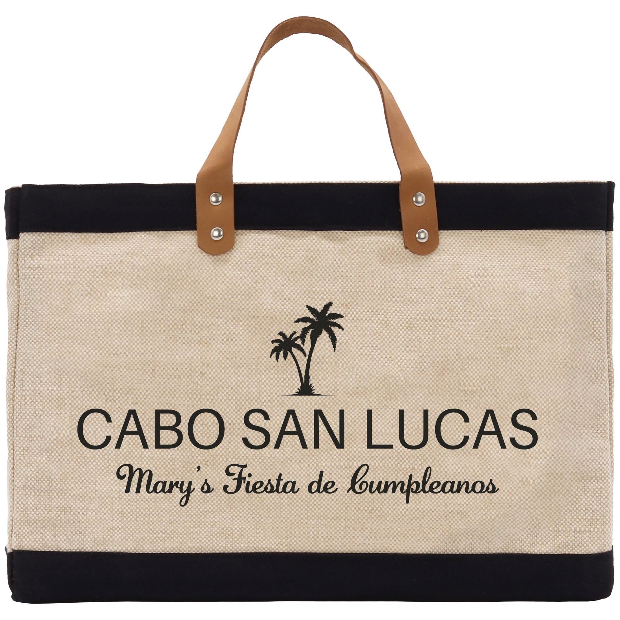 a black and white bag with a brown leather handle
