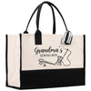 A beige tote bag with black handles and straps, featuring a graphic design of sewing-related items such as scissors and a spool of thread, along with the text "Grandma's Sewing Box".