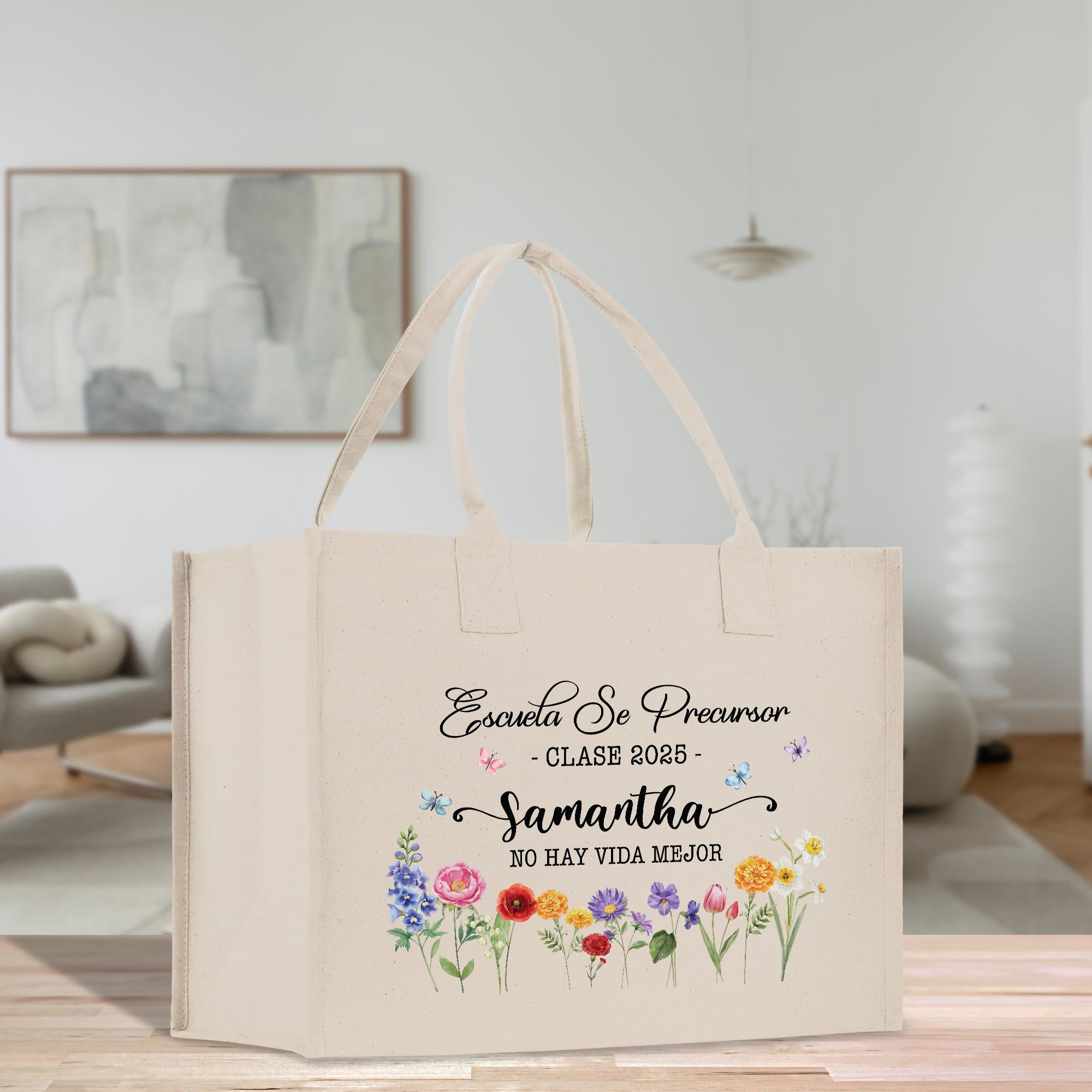 A beige tote bag with a floral design and text printed on it, placed on a wooden surface in a room with a painting hanging on the wall.