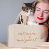 a woman is holding a cat and a bag