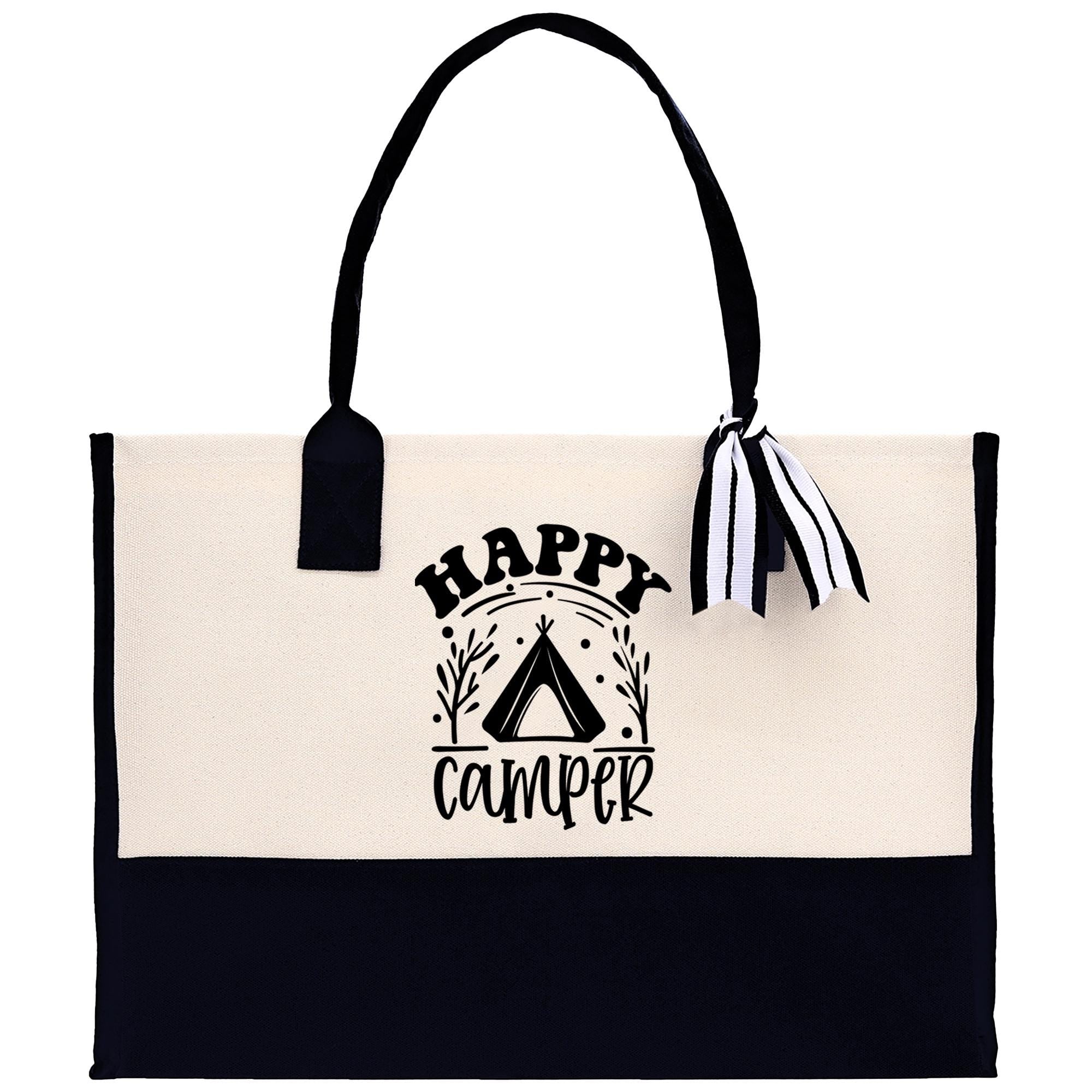 A black and white tote bag with the text "HAPPY CAMPER" printed on it.