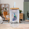 A frosted glass tumbler with a wooden lid and a straw, featuring a colorful illustration of a peacock. The name "Samantha" is written on the tumbler.