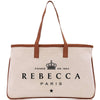 A tan tote bag with a brown leather strap and the text "REBECCA PARIS" printed on it.