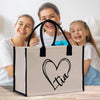 a woman and two girls sitting on a table with a shopping bag