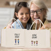 Two white tote bags with text and cartoon characters printed on them, placed on a wooden surface.