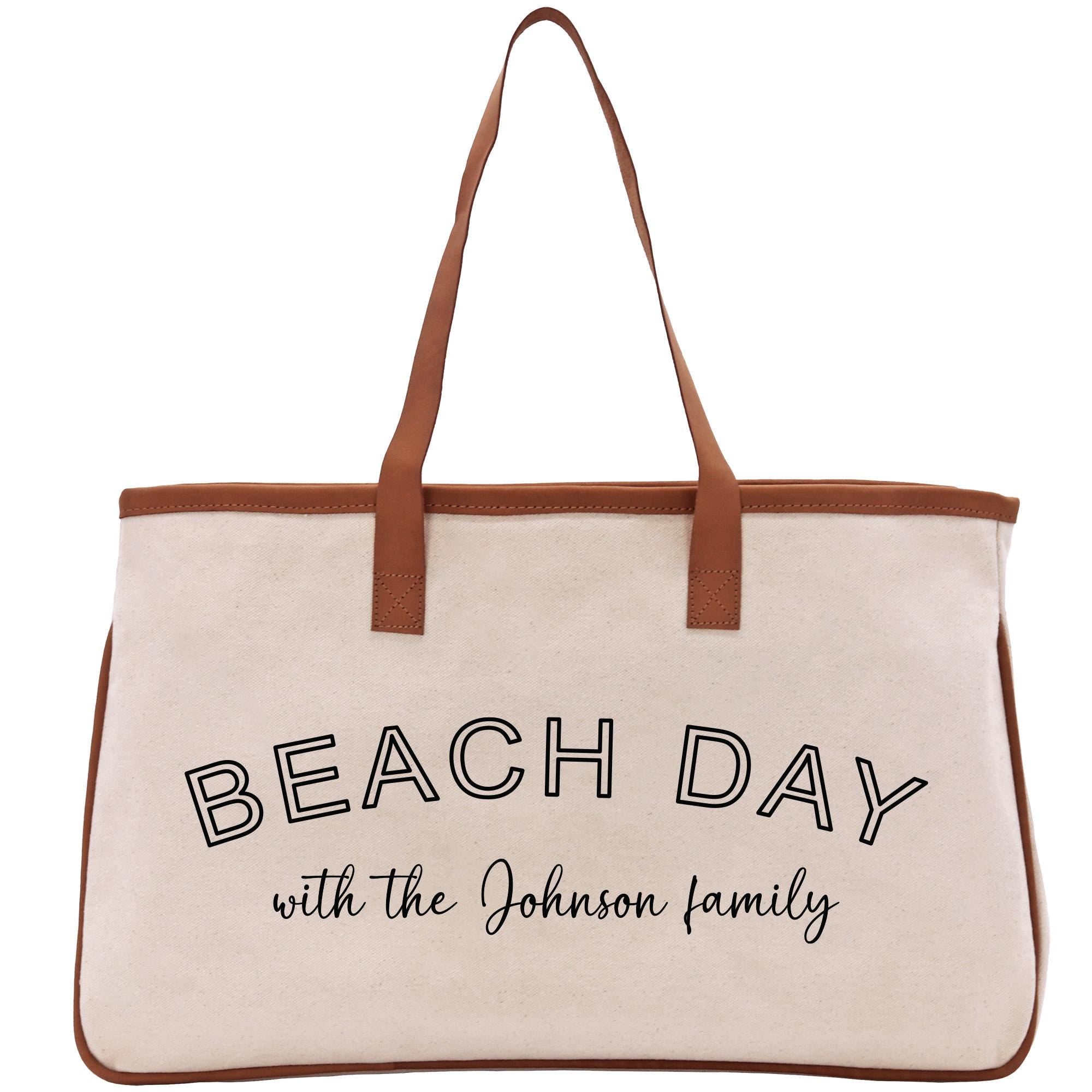 a white beach bag with a brown handle