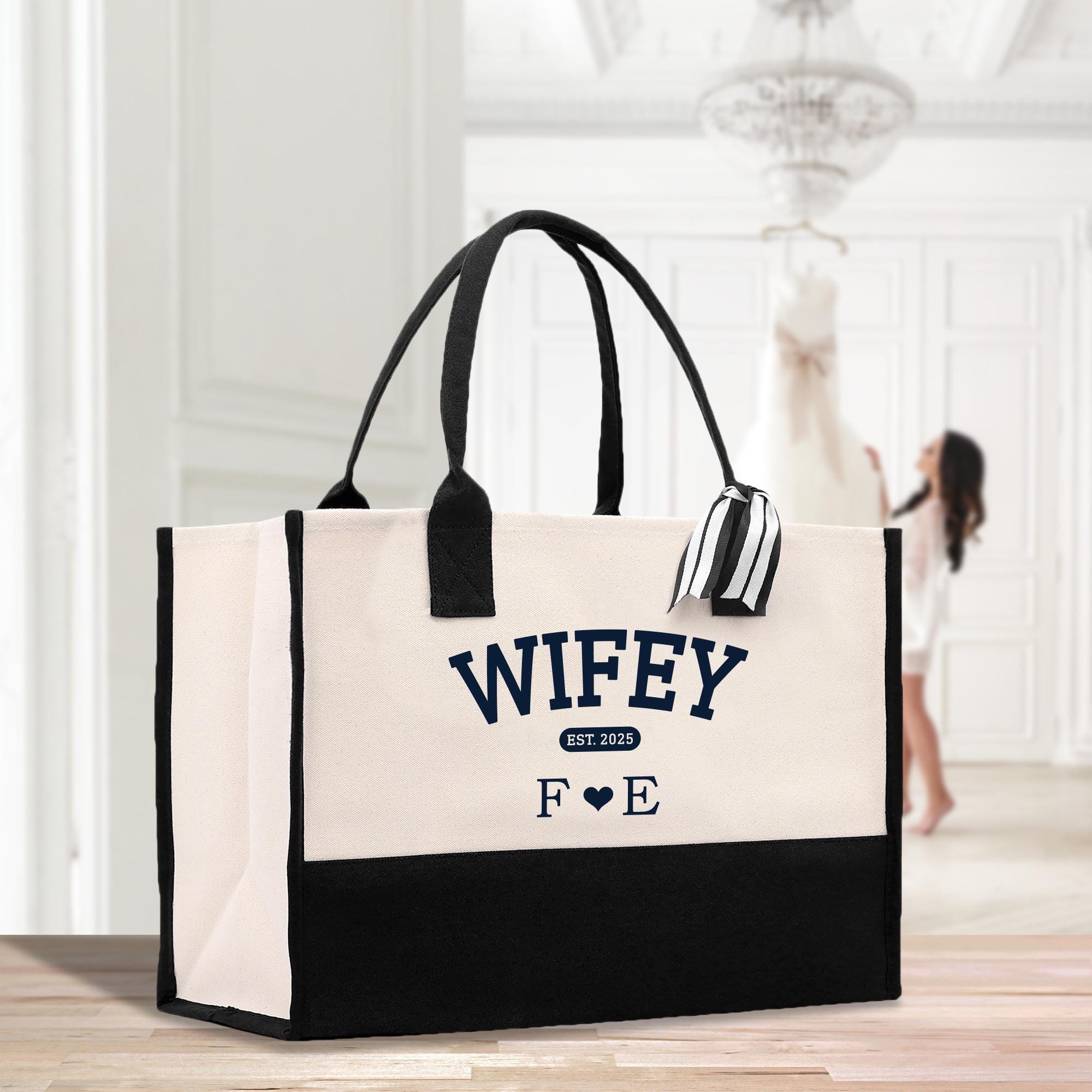 a white and black bag sitting on top of a wooden table