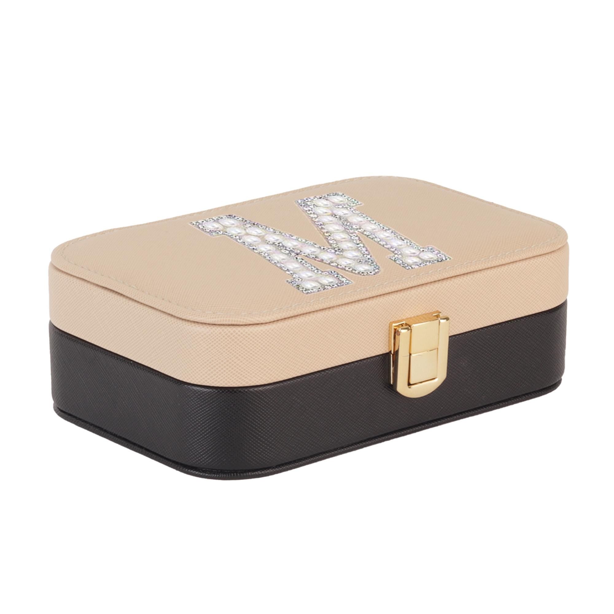 A beige and black jewelry box with a gold-colored lock and a decorative letter &quot;M&quot; on the lid.
