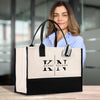 A woman is standing behind a large tote bag with the name 'Kathy Nelson' printed on it.