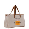 a white canvas bag with a brown leather handle