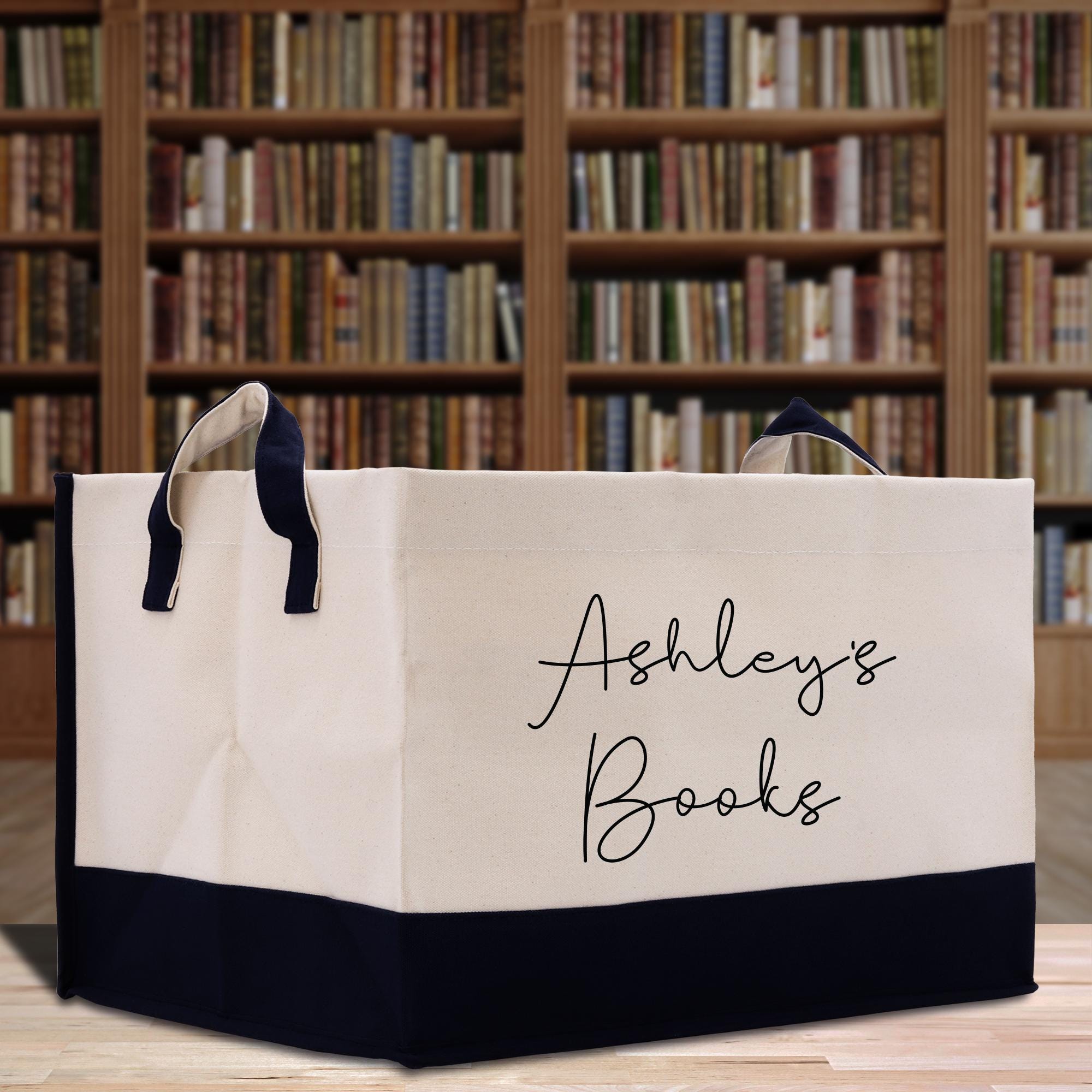 a bag with a name on it sitting on a table in front of a book