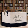 a bag with a name on it sitting on a table in front of a book