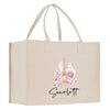 A beige canvas tote bag with a printed image of the Eiffel Tower and pink flowers, along with the name "Scarflett" printed below.