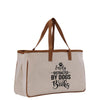 a white canvas bag with a brown leather handle