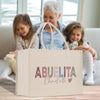 a woman and two girls sitting on a couch with a bag
