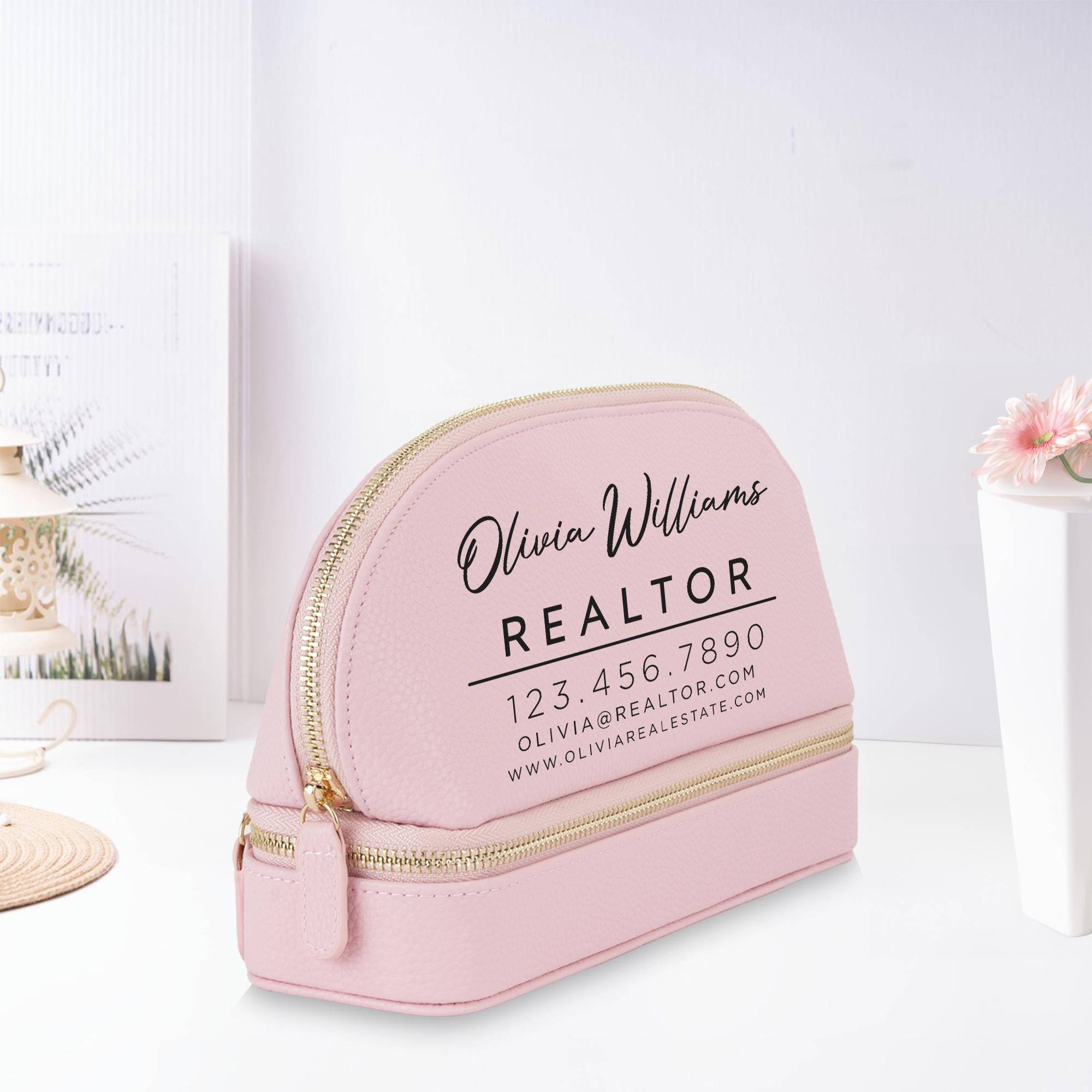 A pink makeup bag with the text &quot;Olivia Williams REALTOR&quot; printed on it, along with a phone number and website.