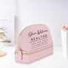 A pink makeup bag with the text "Olivia Williams REALTOR" printed on it, along with a phone number and website.