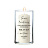 A candle with a message written on it, placed in a glass holder.