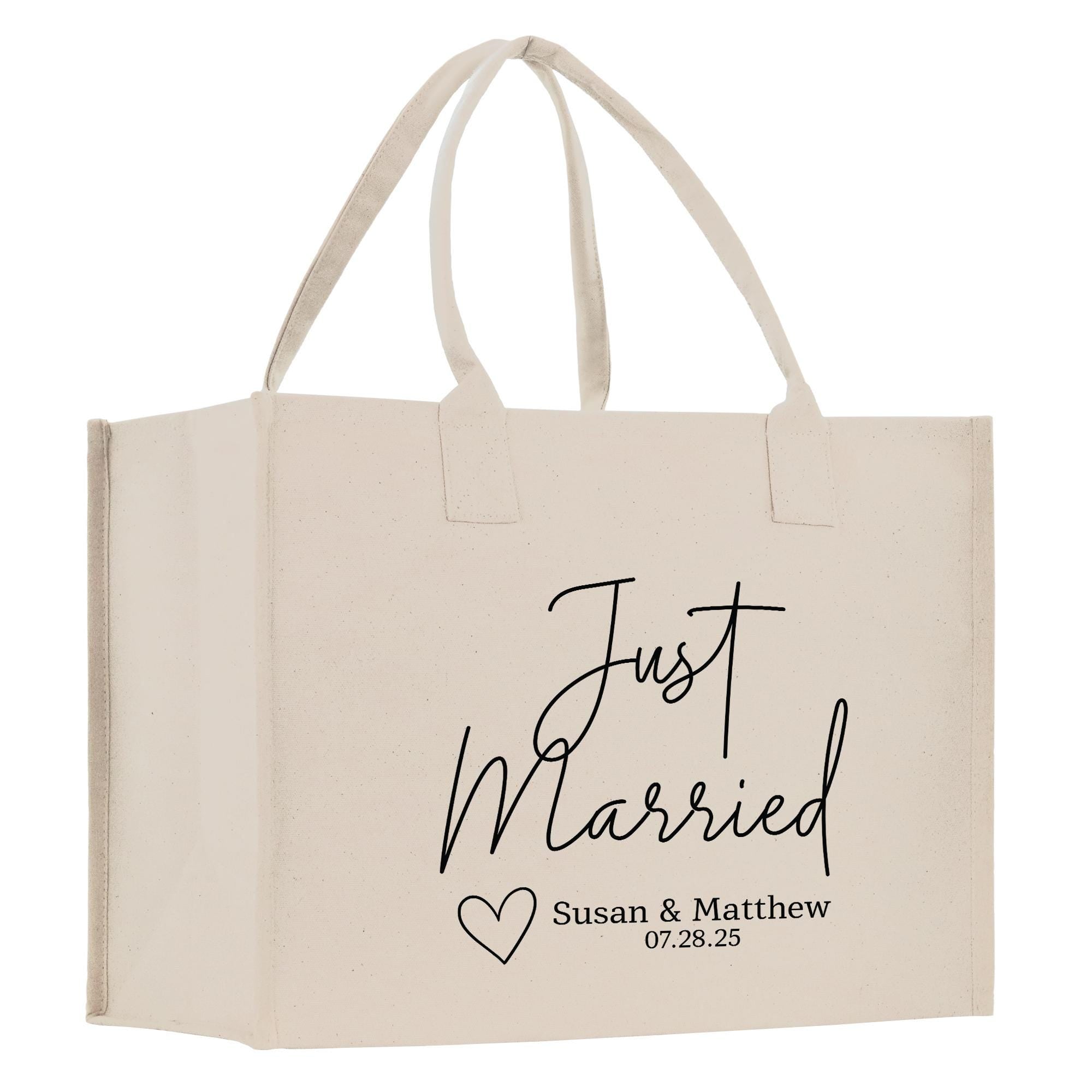 A beige canvas tote bag with the text &quot;Just Married&quot; printed on it, along with a heart symbol and the names &quot;Susan & Matthew&quot; and the date &quot;07.28.25&quot;.