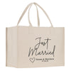 A beige canvas tote bag with the text "Just Married" printed on it, along with a heart symbol and the names "Susan & Matthew" and the date "07.28.25".