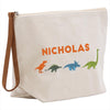 A white canvas tote bag with a zipper closure and a leather strap. The bag has a printed design of four different dinosaurs, including a T-Rex, a Stegosaurus, a Triceratops, and a Velociraptor. The name "NICHOLAS" is printed in orange letters above the dinosaur illustrations.