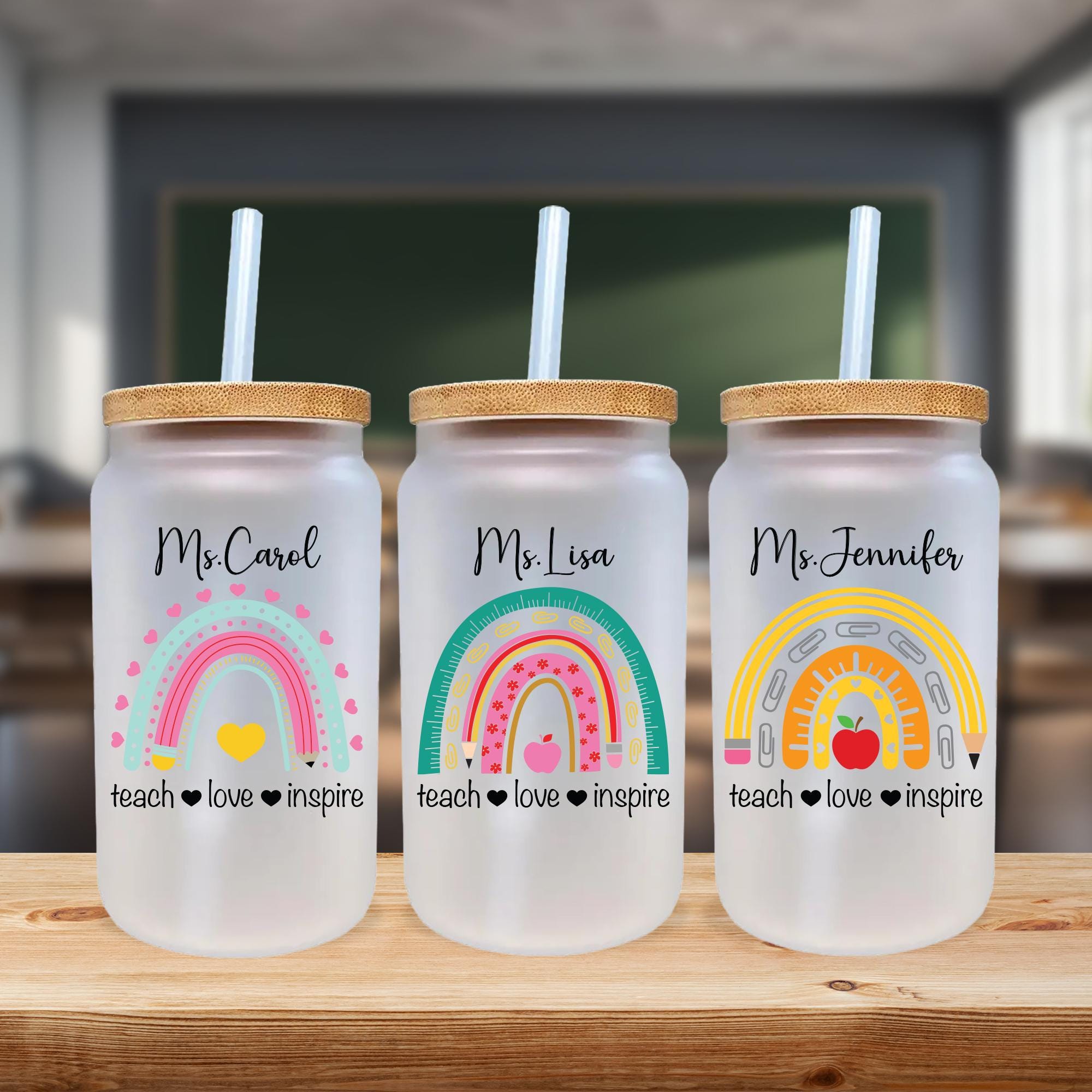 three personalized mason jars with straw tops on a table