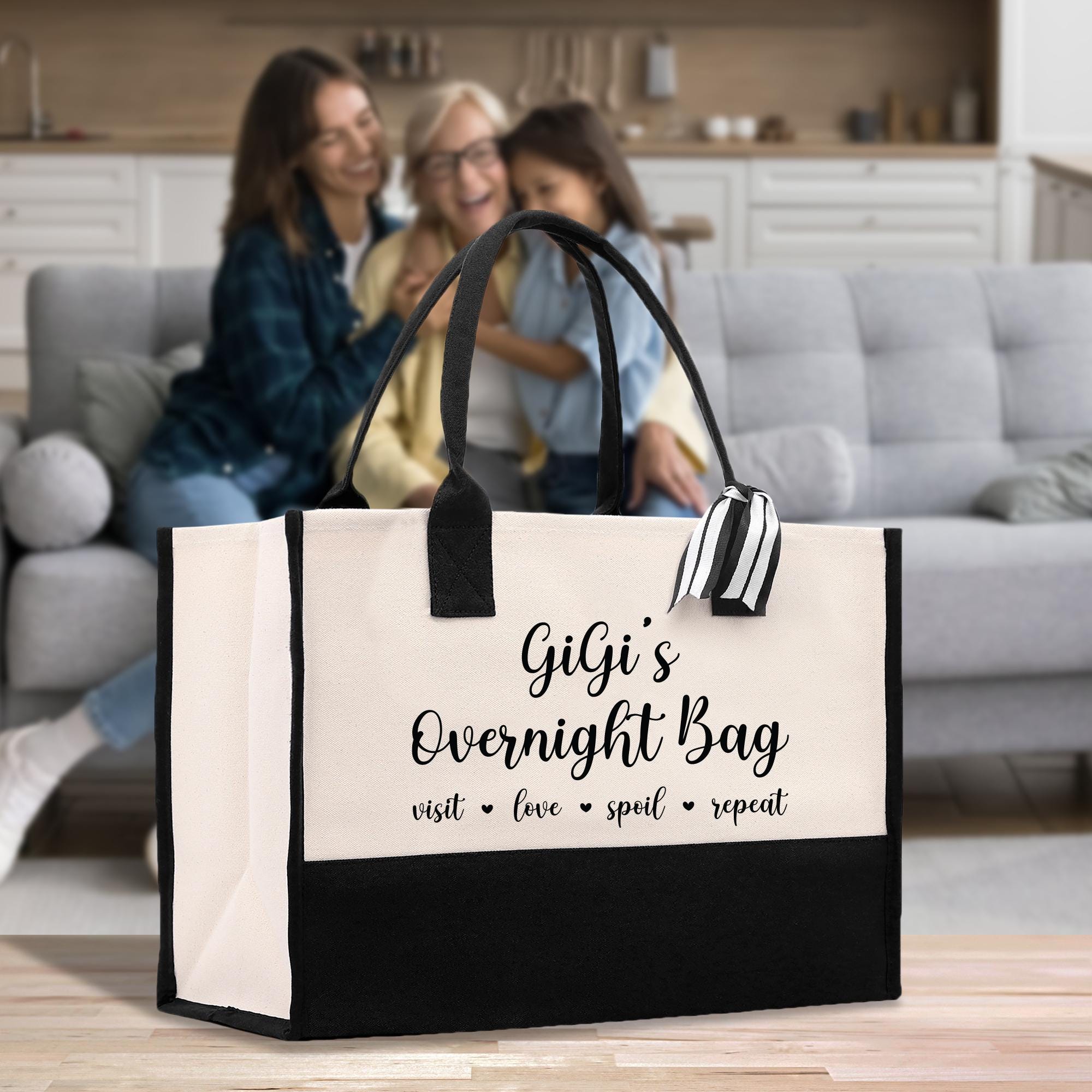 two women sitting on a couch with a bag in front of them