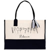 A tote bag with a black and white design featuring various hair styling tools such as a hair dryer, curling iron, and hairbrush, along with the name "Recca" printed on it.