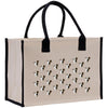 A beige canvas tote bag with black handles and straps, decorated with a repeating pattern of dog faces.