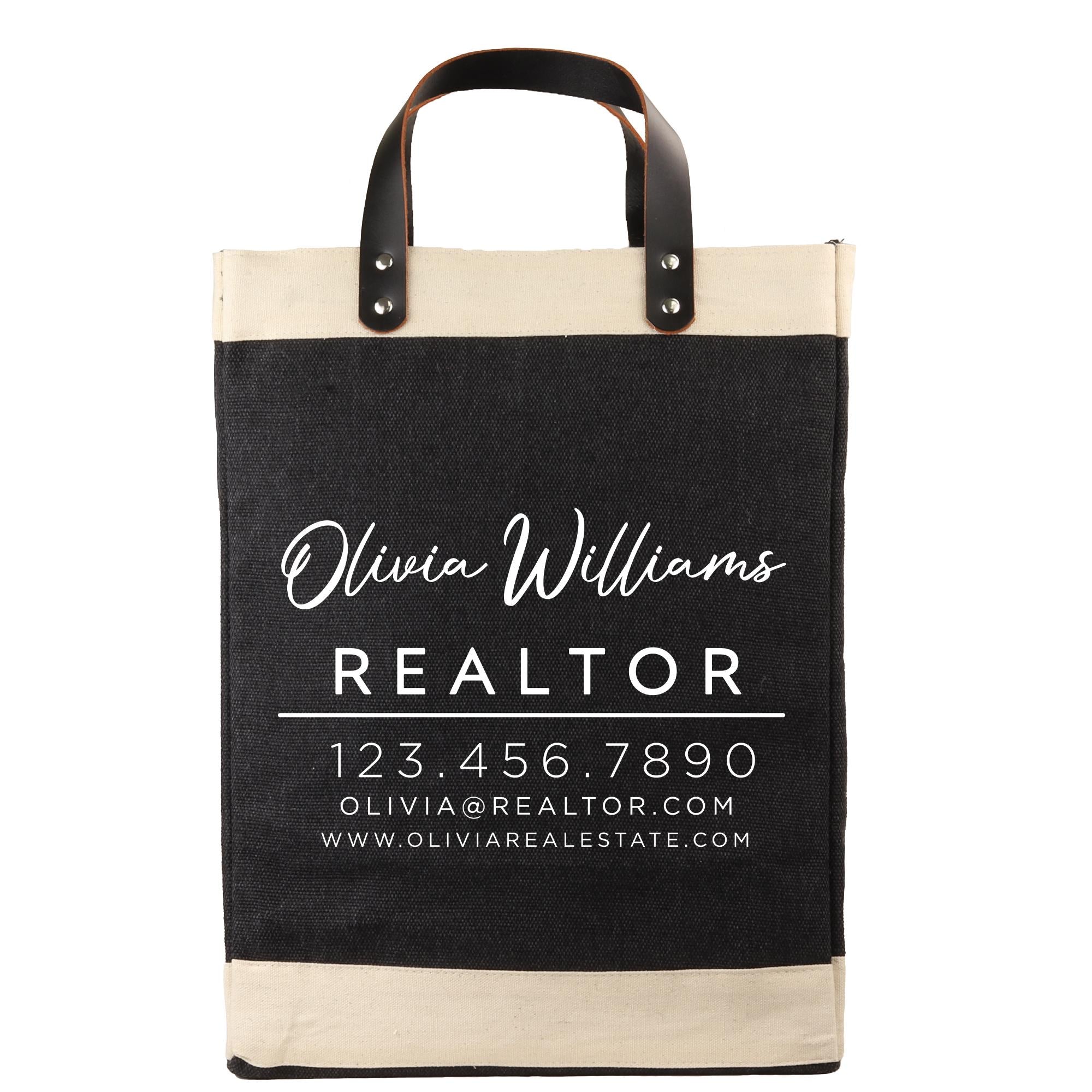 A black and beige tote bag with the text "Olivia Williams REALTOR" printed on it, along with a contact number and website.