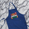A blue apron with the text "COOKIE BAKING CREW" printed on it, along with images of cookies and gingerbread men.