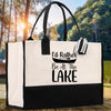 A black and white tote bag with a printed message on it, placed on a wooden surface with a natural outdoor background.