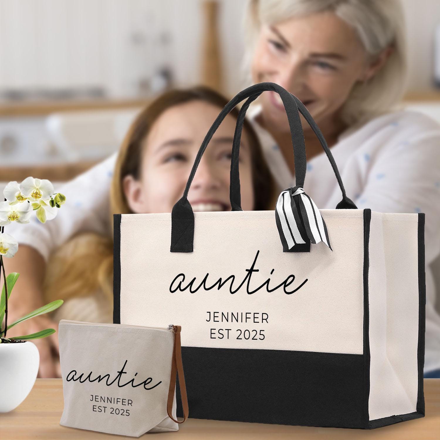 A large tote bag with the name &quot;auntie&quot; printed on it, along with a smaller bag and a woman&#39;s face in the background.