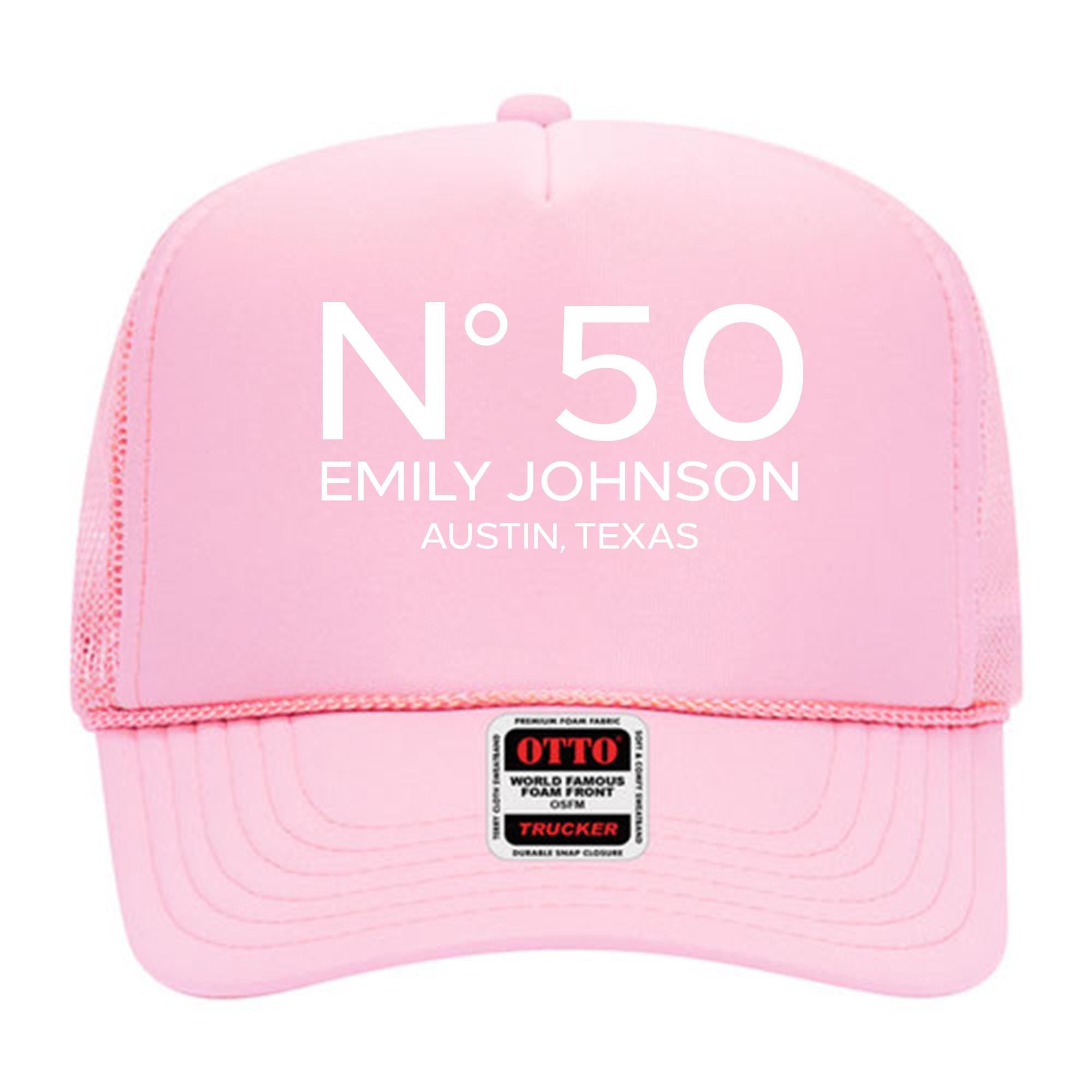 A pink trucker hat with the text &quot;N°50 EMILY JOHNSON AUSTIN, TEXAS&quot; printed on it.