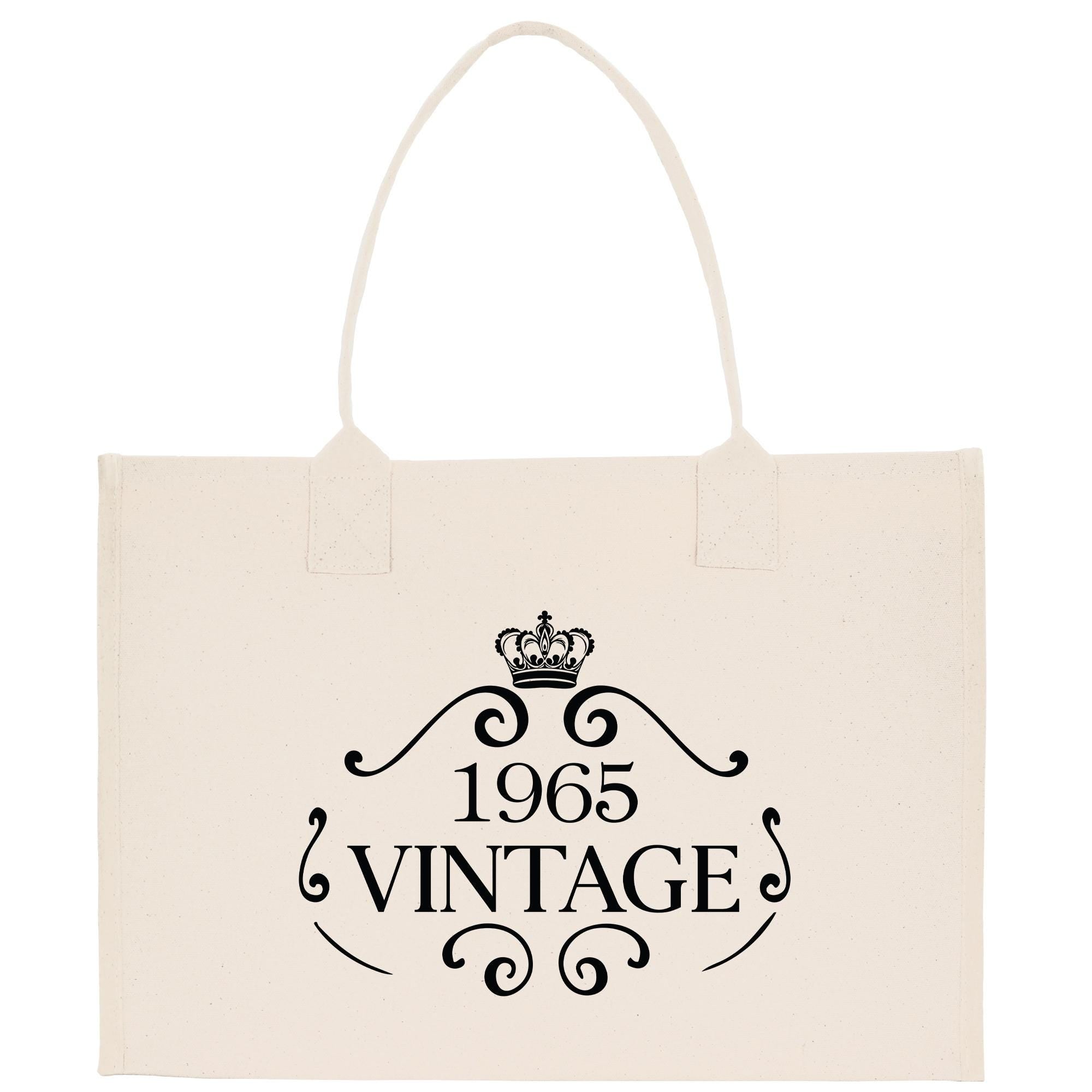 A beige canvas tote bag with a black text design that reads "1965 VINTAGE".
