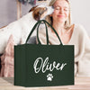 a woman holding a green shopping bag with a dog's paw on it