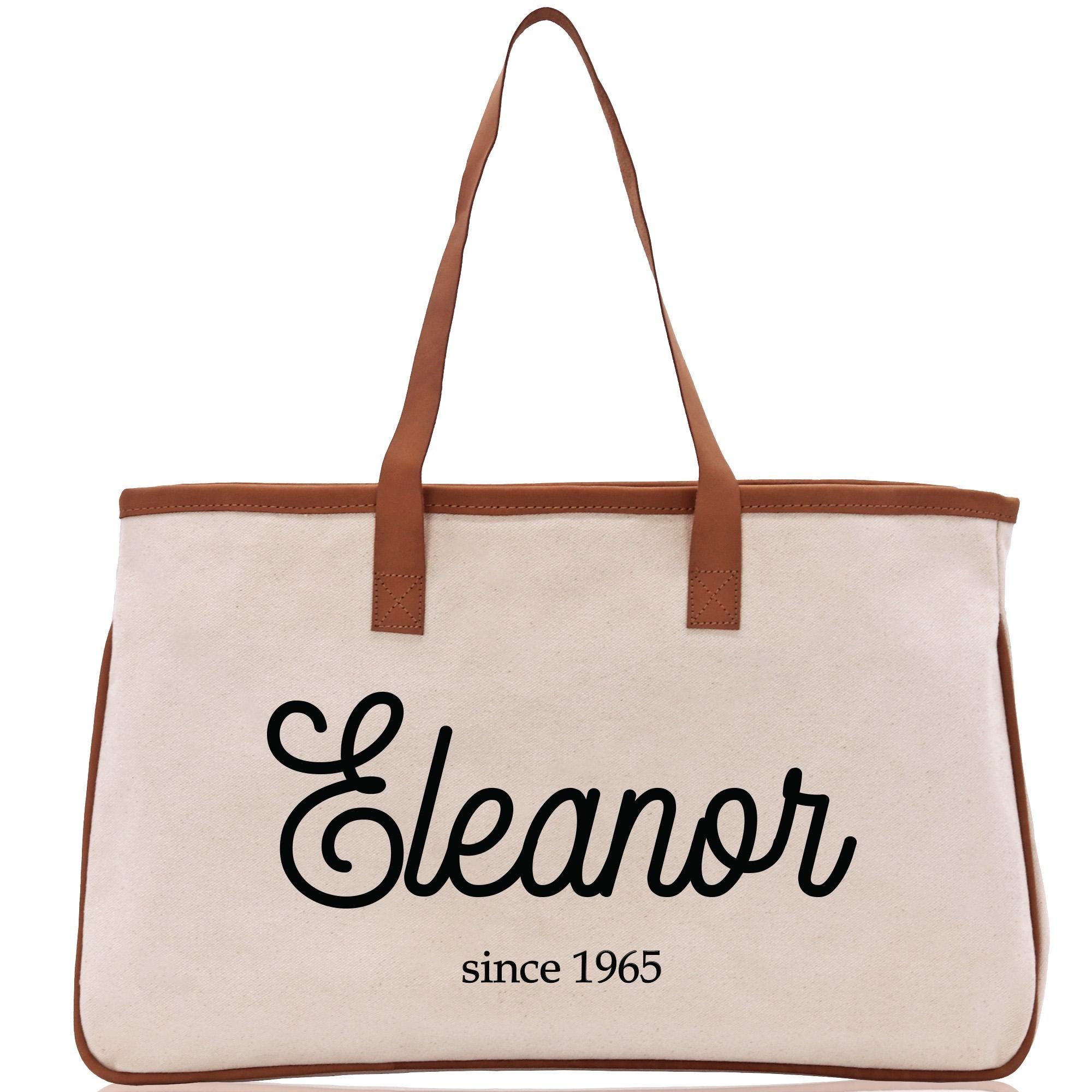 a white canvas bag with a brown leather handle