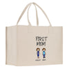 A beige canvas tote bag with a printed design featuring two cartoon-style figures and the text "FIRST MOM" above them.