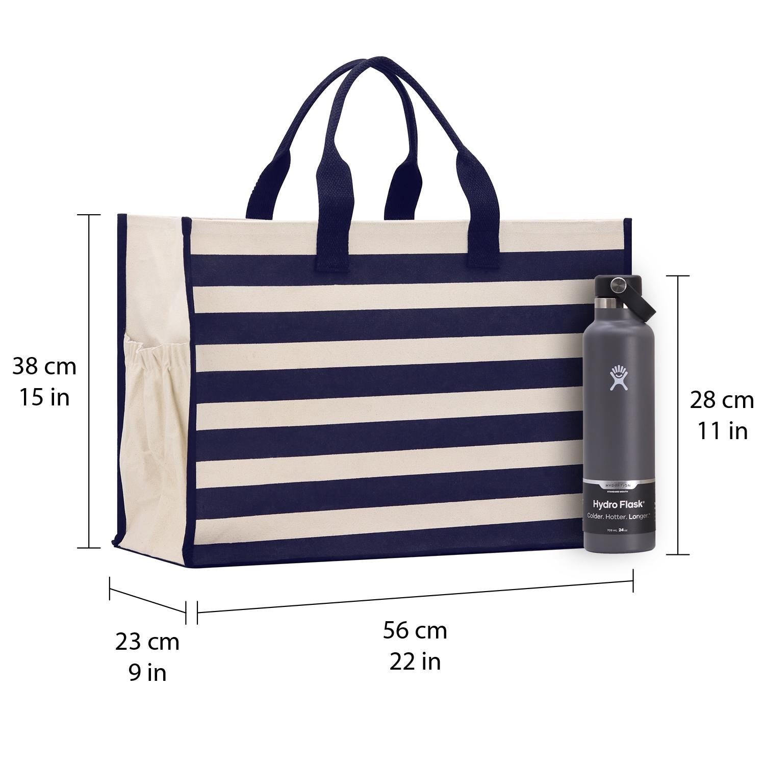 a large blue and white striped tote bag with a handle and a water bottle next to it. The bag is 38 cm long, 15 cm wide, 23 cm tall, and 56 cm wide. The water bottle is 28 cm tall, 11 cm wide, and 22 cm tall.