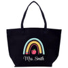 a black tote bag with an apple and rainbow